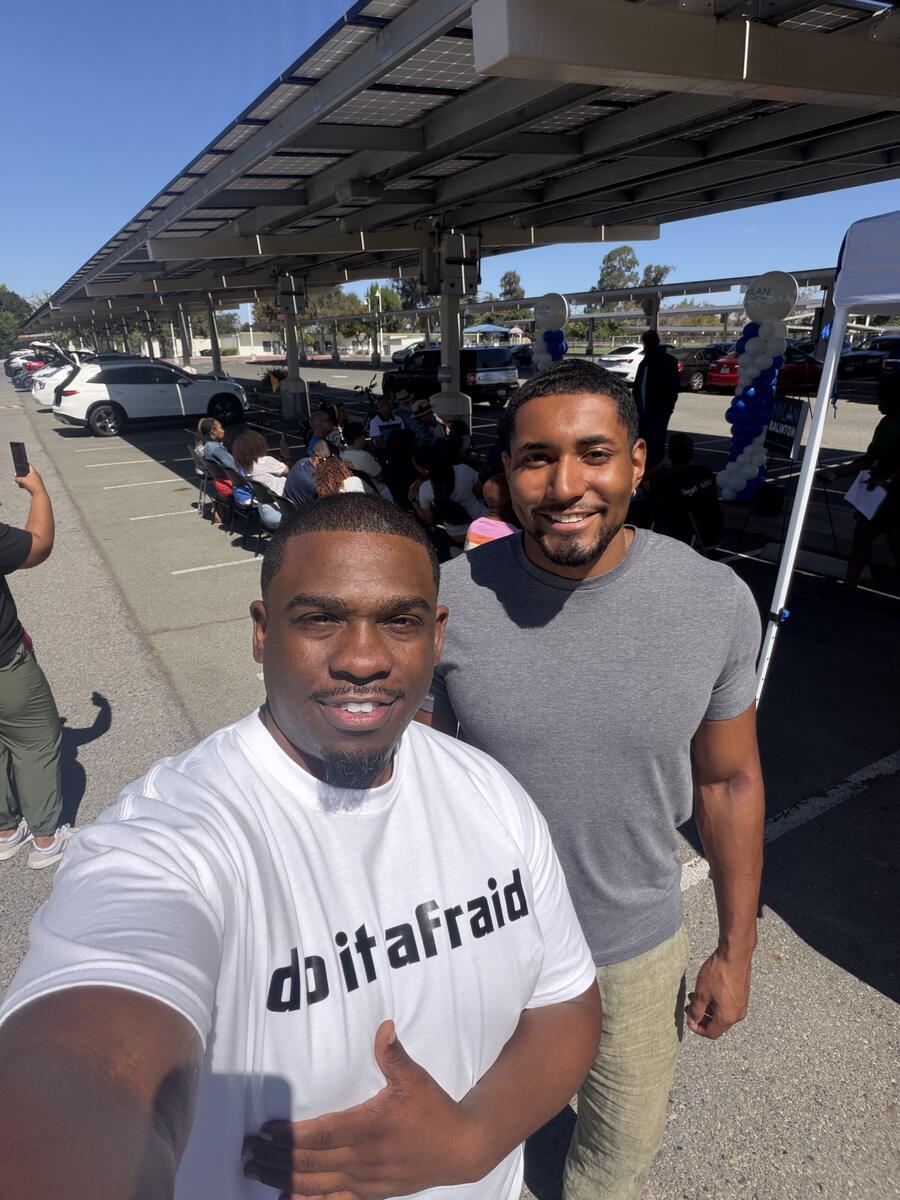 Milan Balinton takes a selfie with a supporter at an outdoor campaign rally